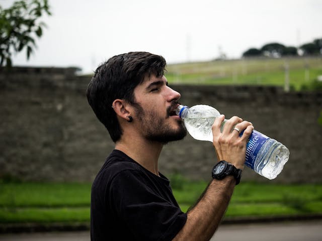man drinking bottle of mineral water