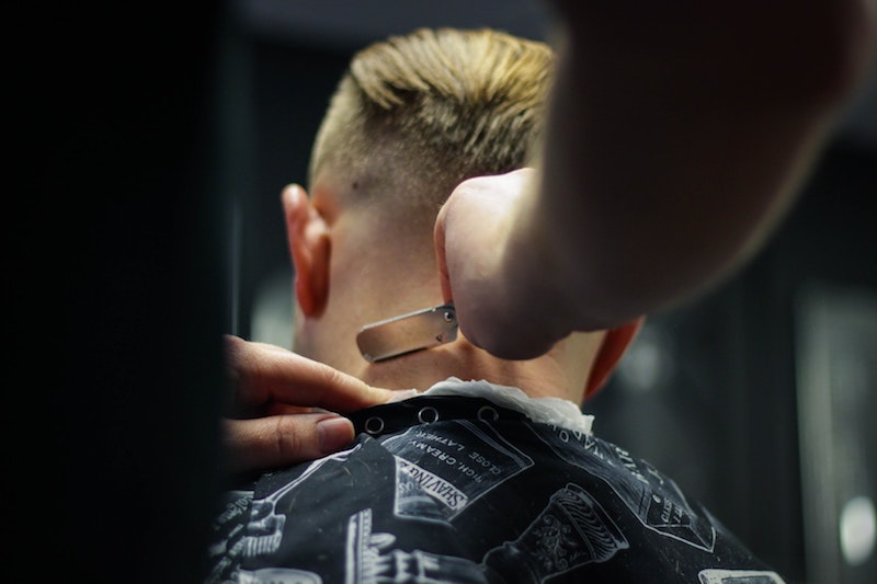 barber trimming back of mans neck