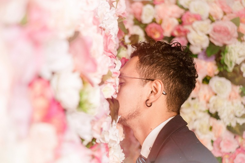 man smelling wedding flowers