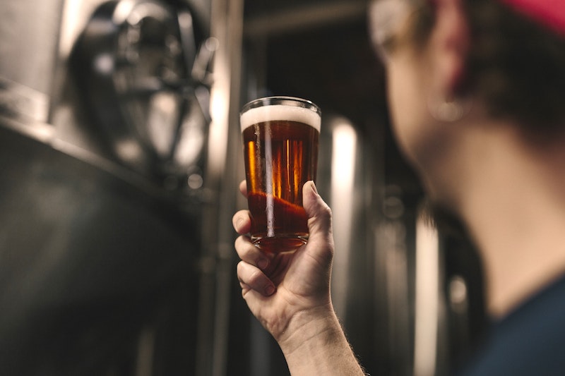 man holding glass of beer